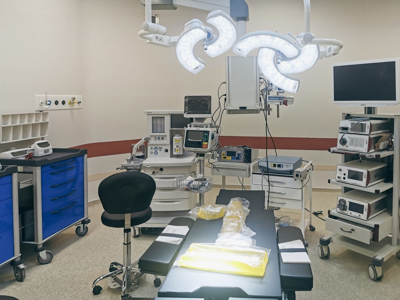 Bloc opératoire vide d'un établissement de santé avec scialytique, moniteurs, chariots médicaux et table d'opération