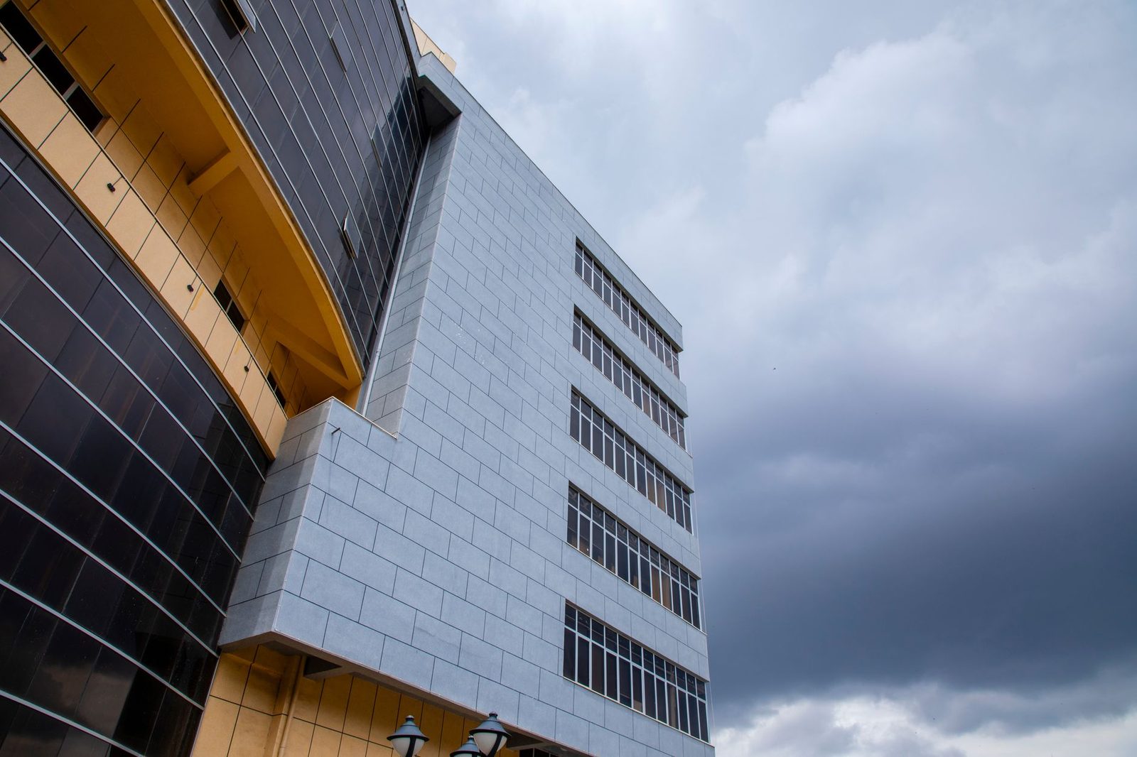Façade moderne d'un immeuble de bureaux vue en contre-plongée sous un ciel nuageux
