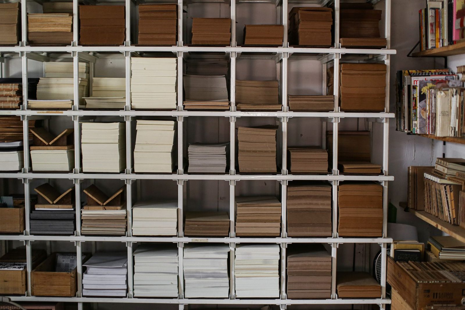 Regal mit Fächern voller Papierstapel, Hefte und abgelegte Dokumente in einem Archivraum