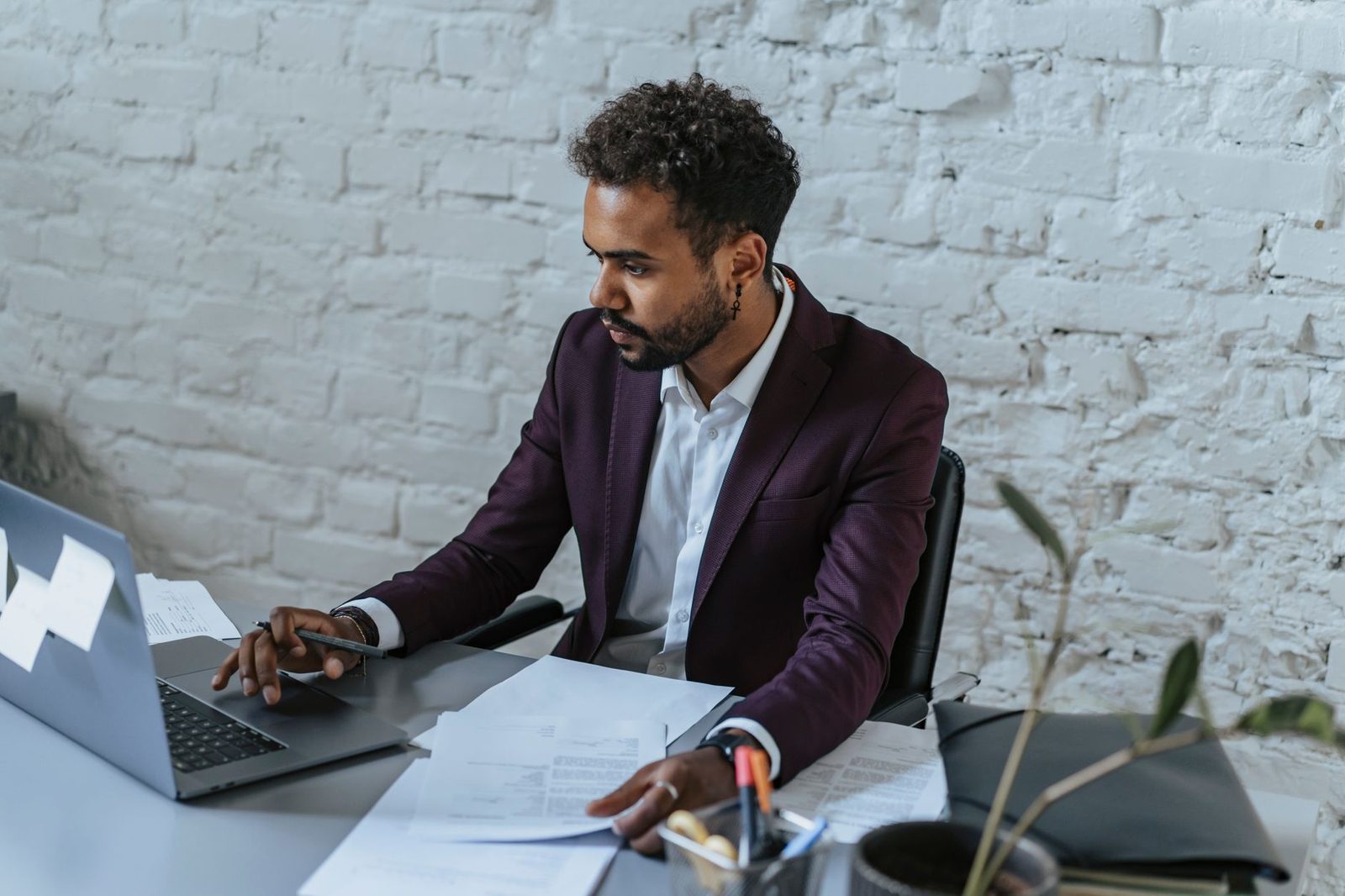Homme en costume travaillant sur un ordinateur portable avec des documents juridiques sur son bureau